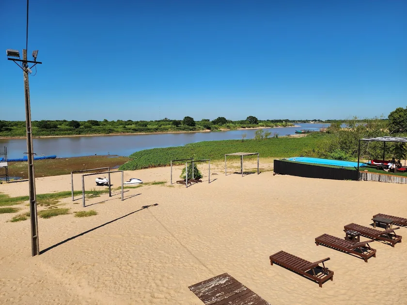 Vista amplia de la arena y el deck de CostaMansa con el río de fondo